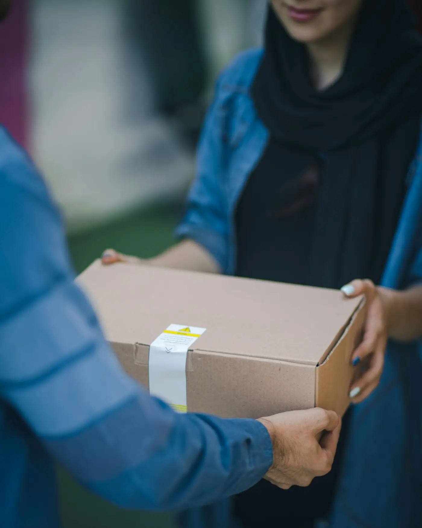 A labelled parcel being passed between two people