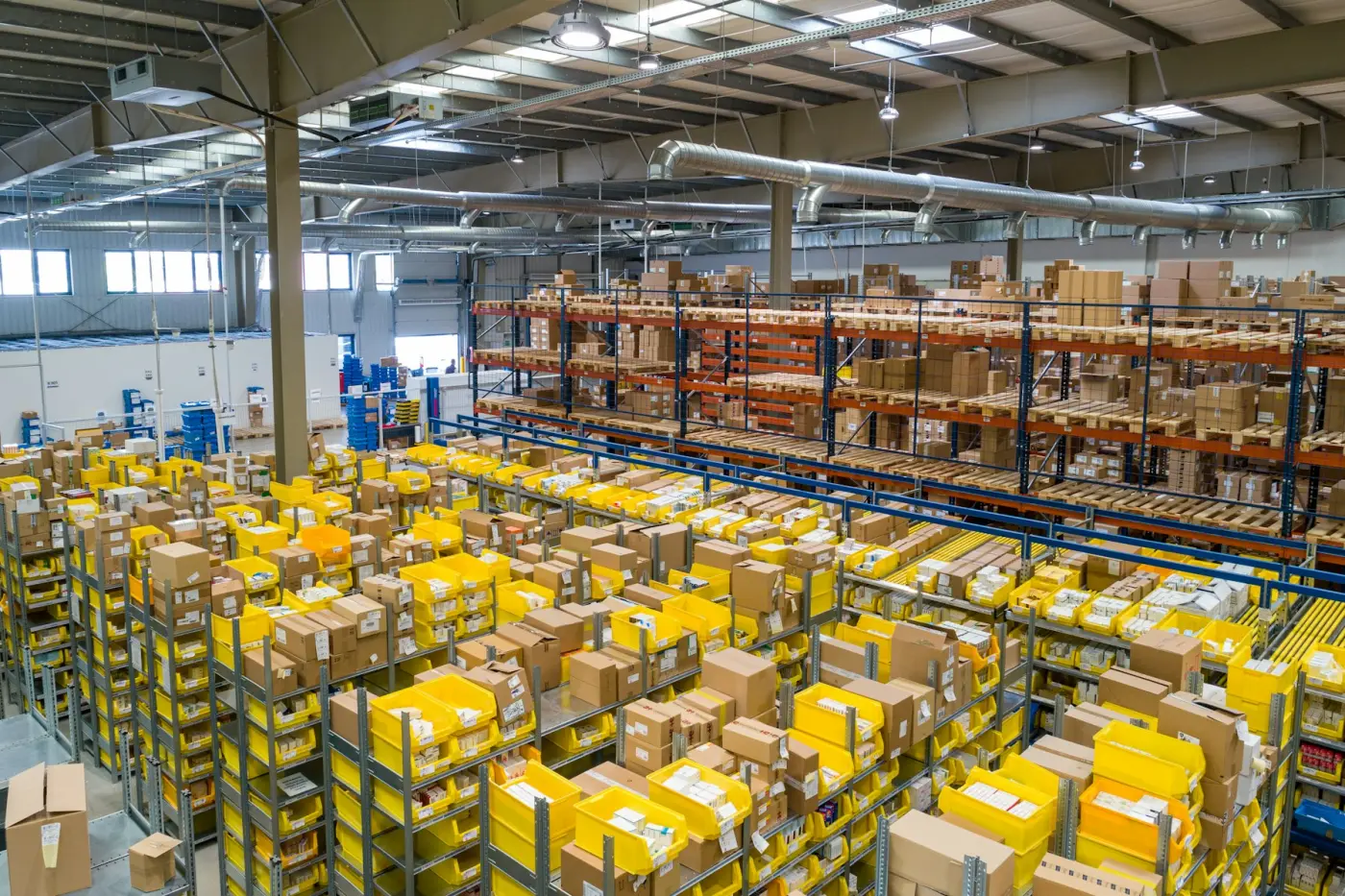 Warehouse interior with pick-face shelving and pallet racking full of cartons